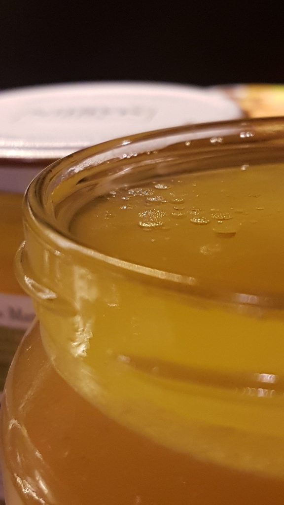 Bone broth filled jar with macro focus on the upper surface